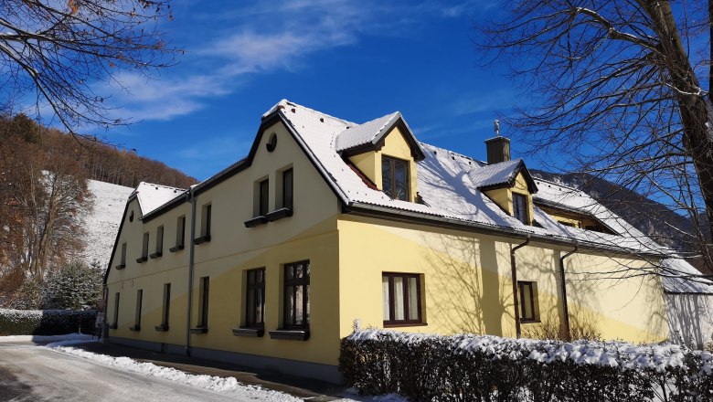 House view in winter, © Gudrun Rath Yellow house with snow-covered roof in winter, blue sky.