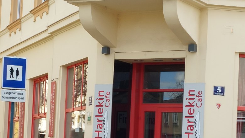 Entrance to Cafe Harlekin with red door and ice cream cone decoration.
