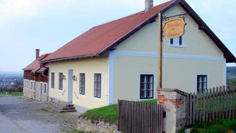 Winegrower's house with yellow façade and red roof in a rural setting.