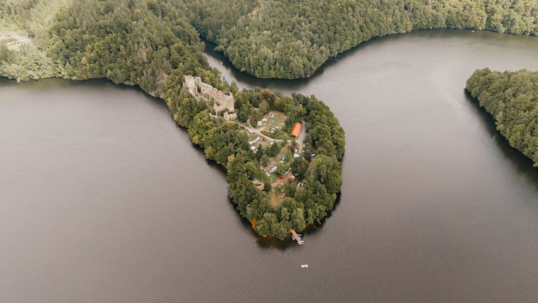 Aerial view of the Dobra ruins on a wooded peninsula surrounded by a river.