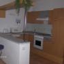 Modern kitchen with wooden cupboards, bar stools and appliances such as microwave and stove.