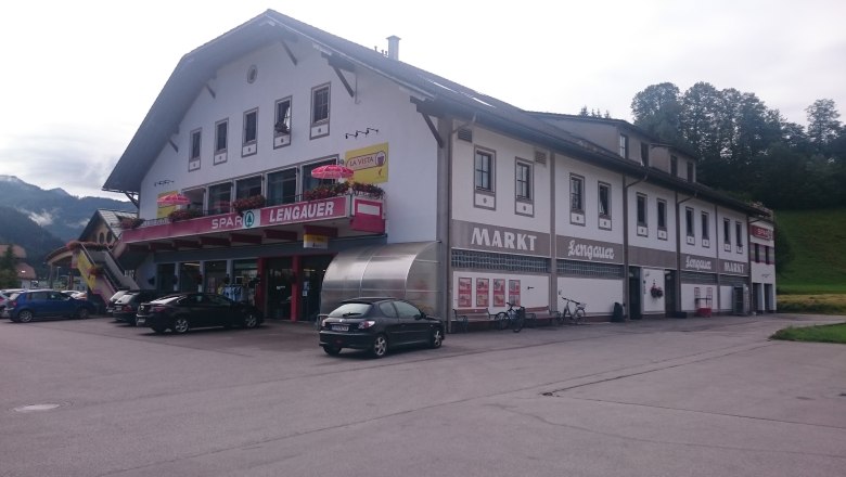A supermarket labeled 'Spar Markt Lengauer' in a two-story building with parked cars in front of it.