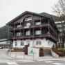 Hotel Schneeberghof in a mountainous setting with traditional architecture and a large sign in front of the building.