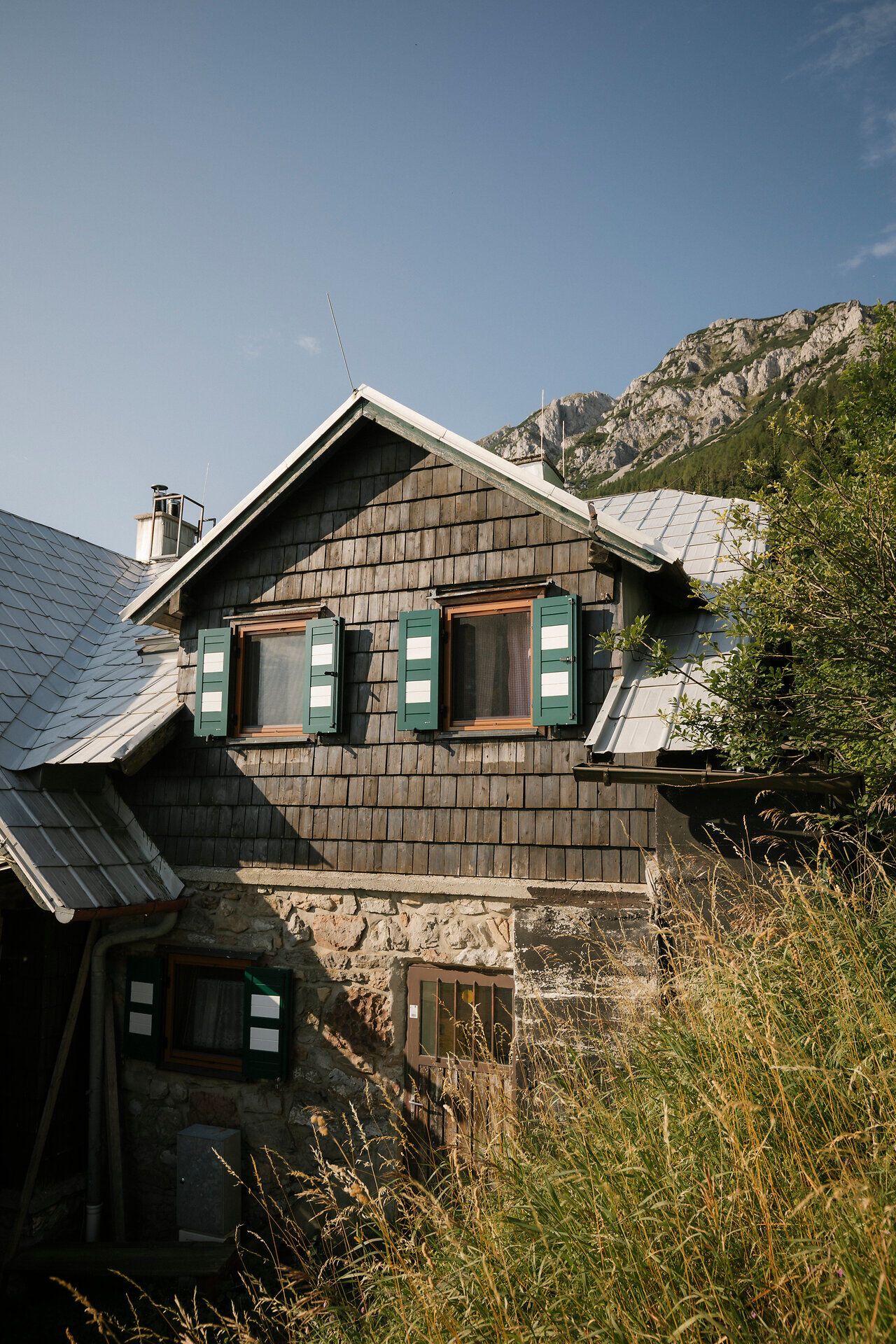 Exterior view of the Edelweißhütte on Schneeberg, with its shingle facade and green shutters