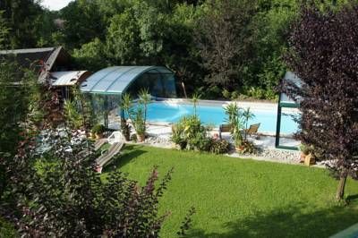 A garden with pool and canopy, surrounded by trees and lawn.