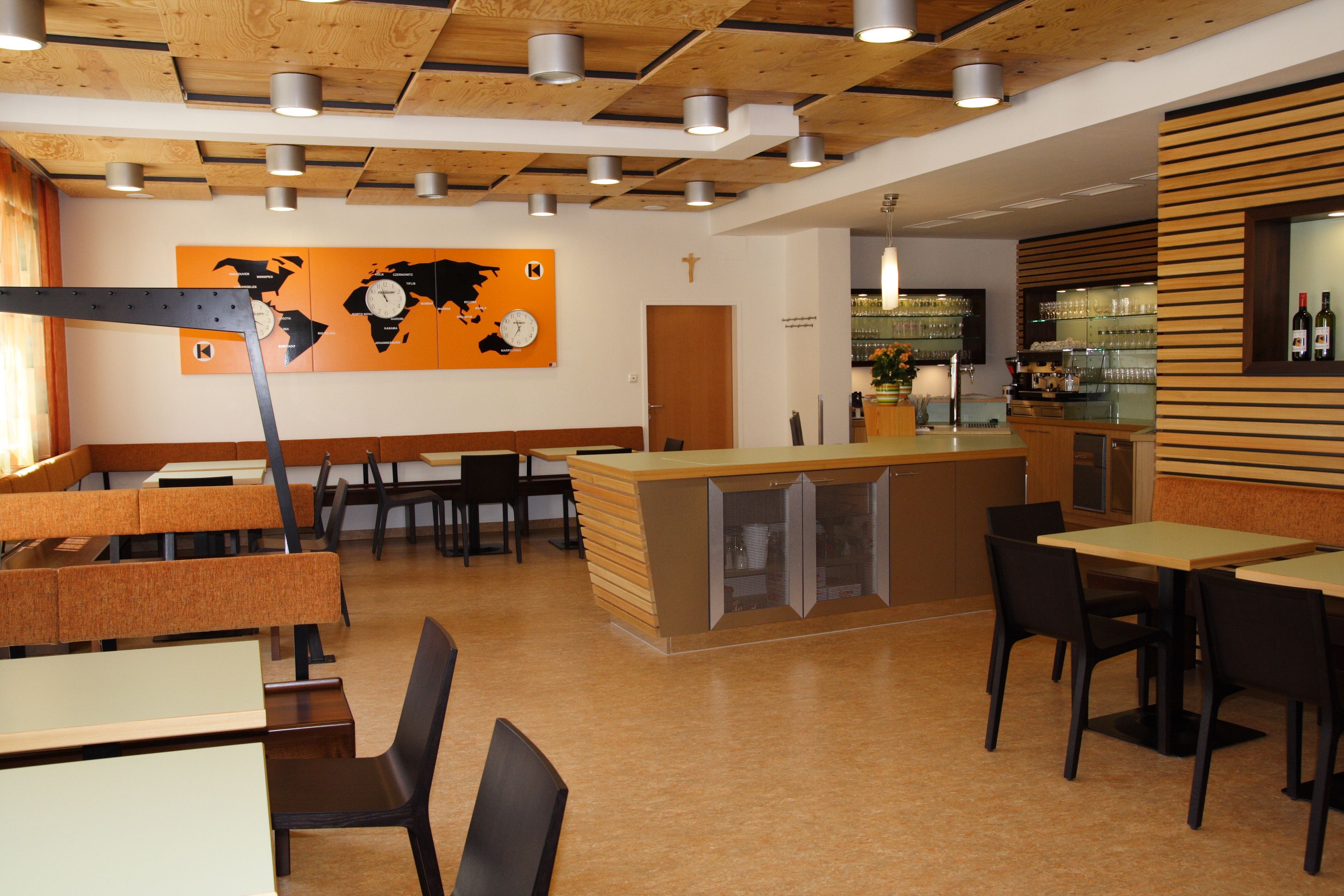 Interior view of a modern restaurant with wooden elements and world map decor.