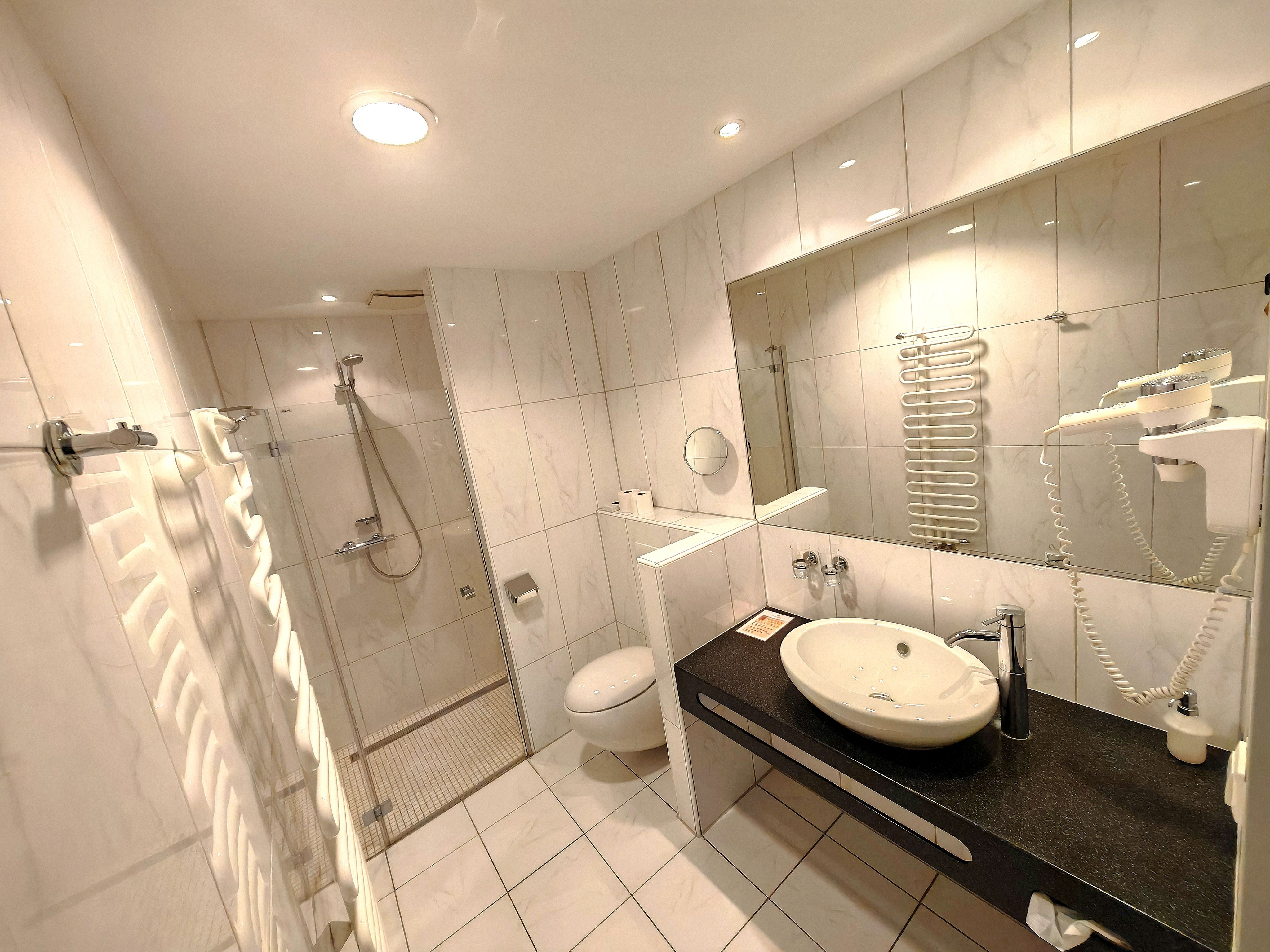 Modern bathroom with a shower, sink, and toilet.