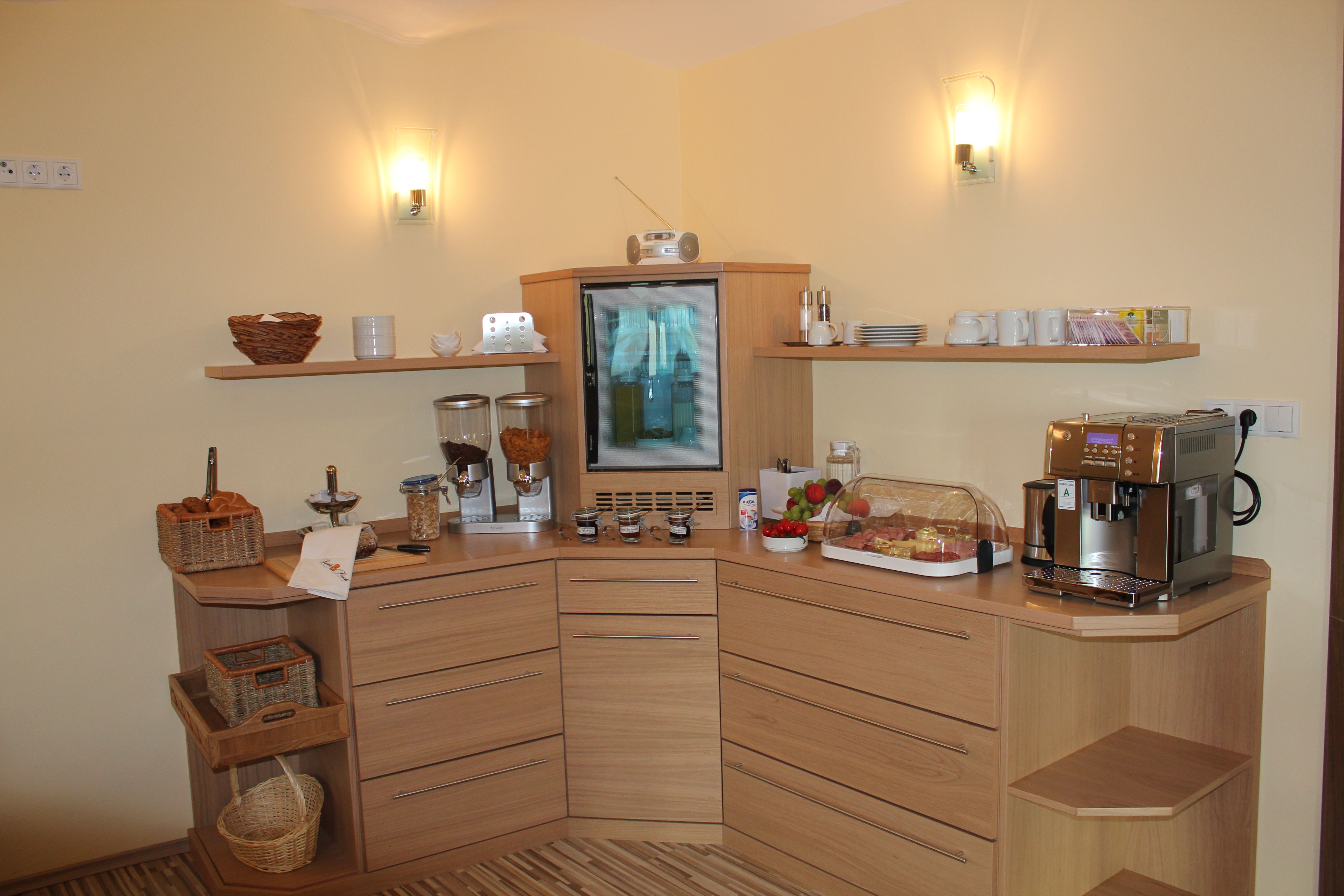 Breakfast buffet in a guest house with coffee machine, muesli, fruit and cold cuts.