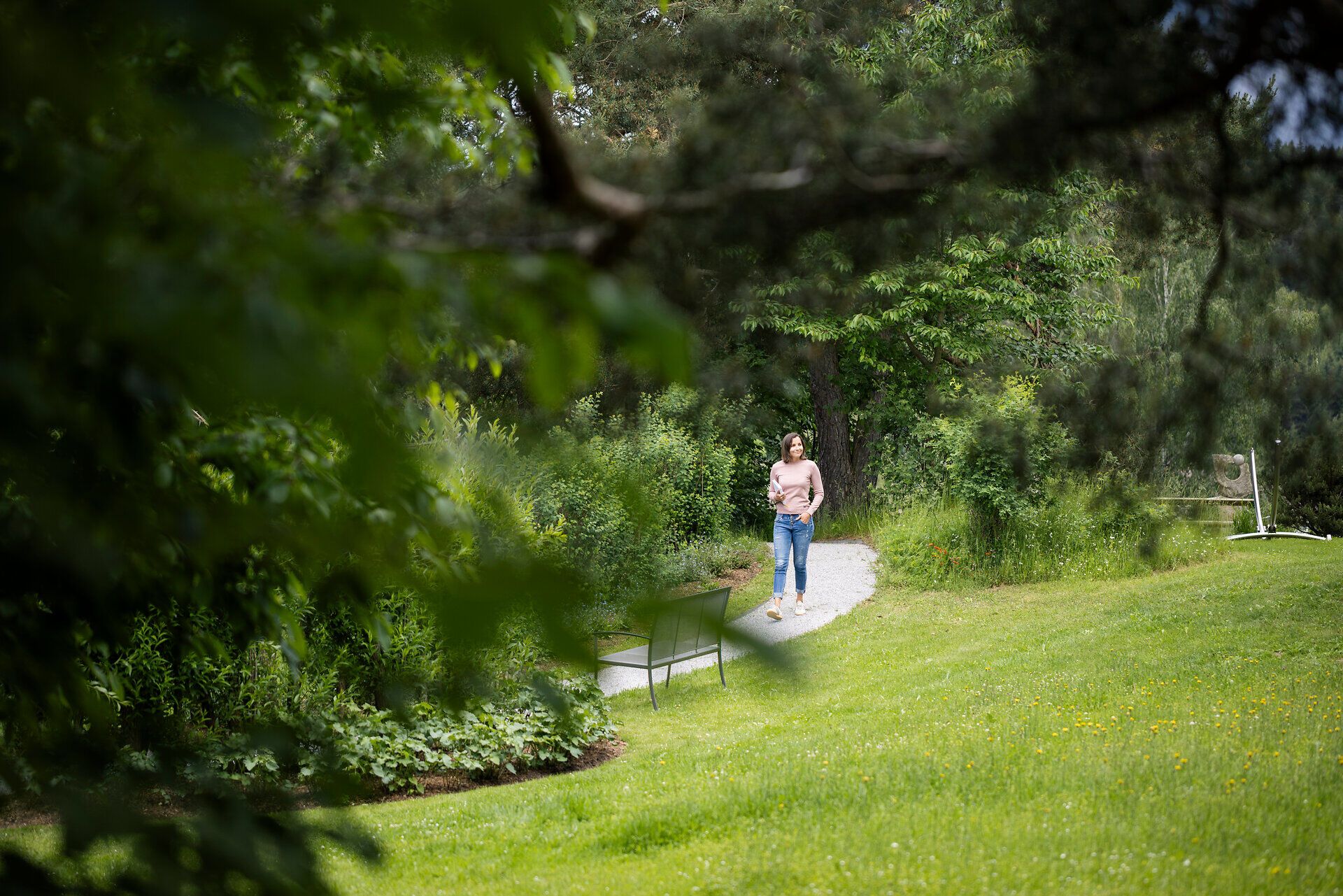 A woman is walking through the garden of the Klosterberg Health Hotel in the Waldviertel region.