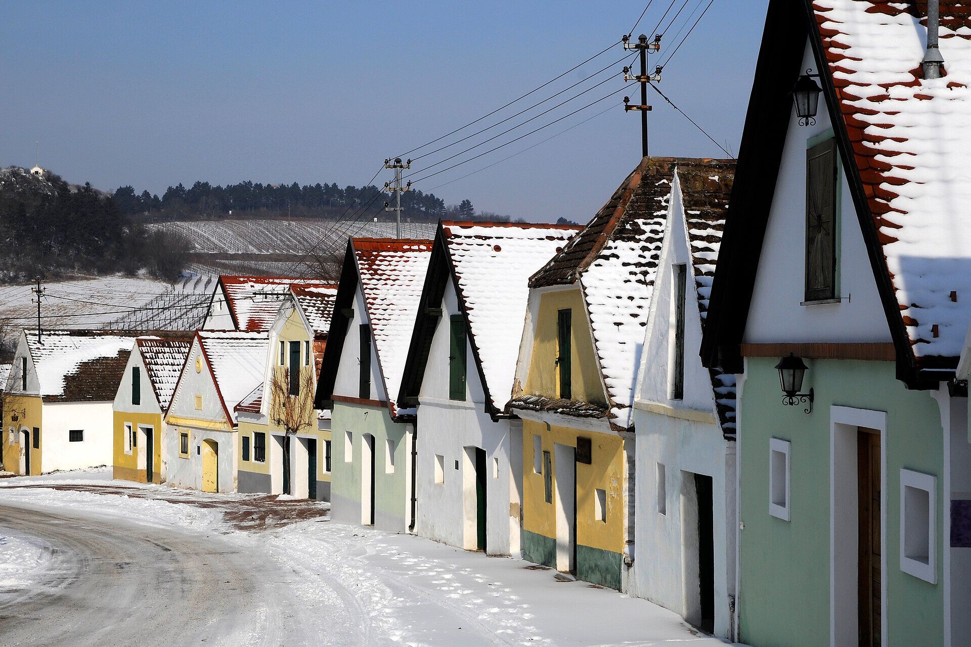In dieser malerischen Gasse, umgeben von schneebedeckten Dächern, strahlt die winterliche Idylle eine ruhige Gemütlichkeit aus. Die bunten Fassaden der Hütten laden dazu ein, die Schönheit der Natur zu genießen und die frische, klare Luft zu atmen.