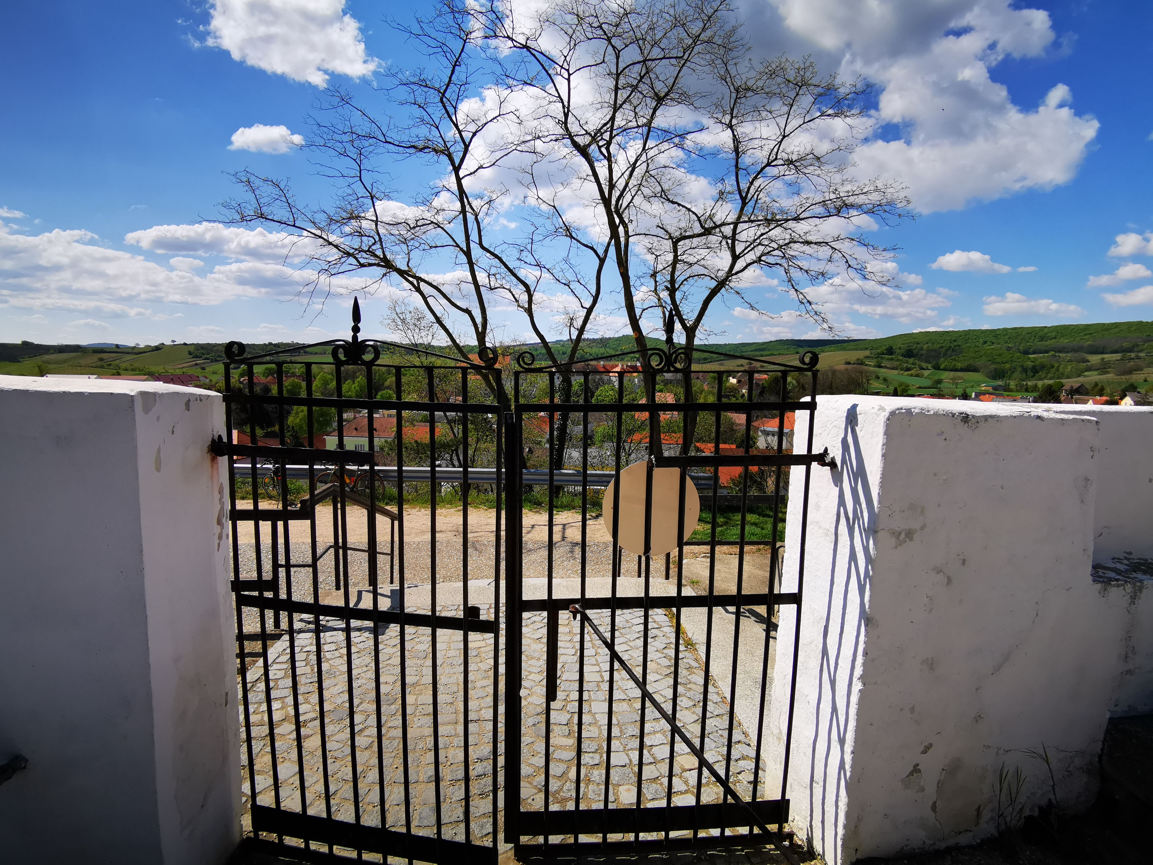 Iron cemetery gate with a view of the countryside and village.