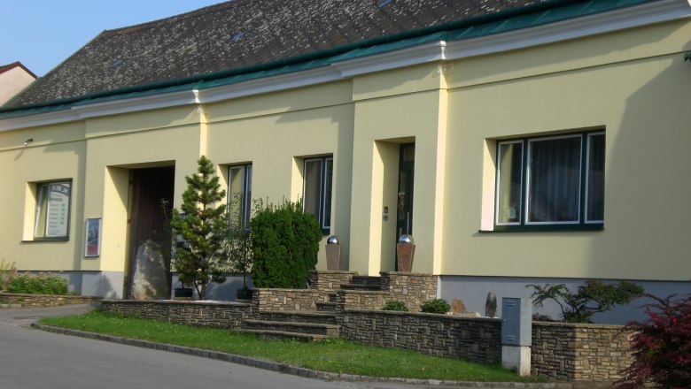 Kriegl Winery, © Fam. Kriegl Yellow building with stone wall and plants in front of the entrance.