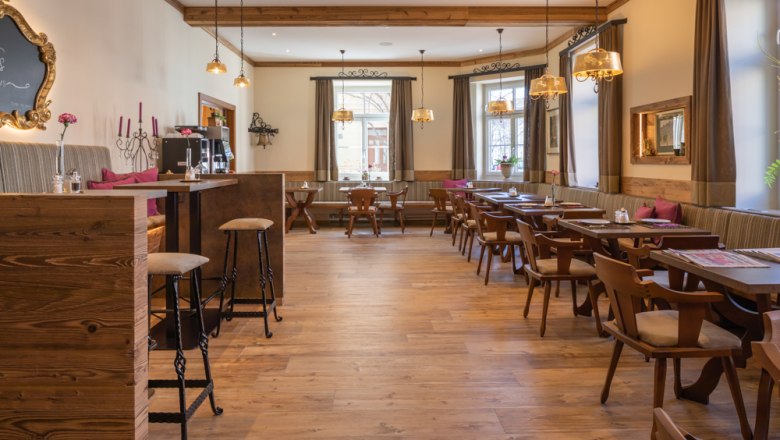 Cozy breakfast area with wooden furniture and large windows.