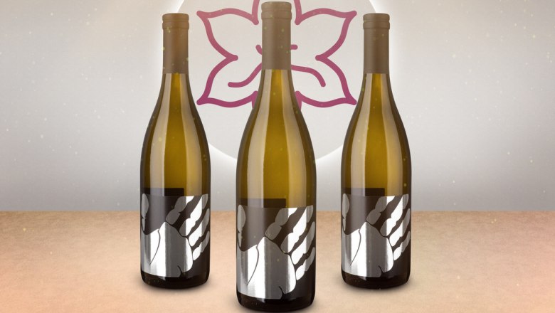 Three wine bottles with a modern label in front of a stylized flower.