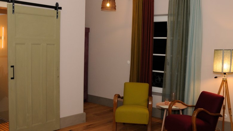 Cozy room with two armchairs, curtains and floor lamp.