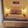 Cozy double room with wooden bed and bedside lamps.