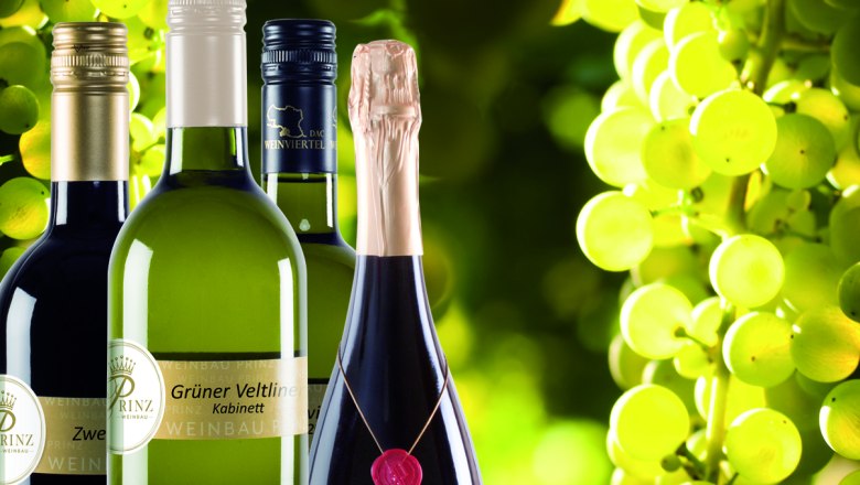 Wine bottles against a background of green grapes.