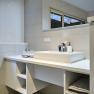 Modern bathroom with white washbasin, mirror and towels.