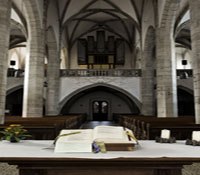 Interior view of a church with altar and organ in the background.