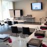 A seminar room with tables, chairs, folders and water bottles, ready for an event.