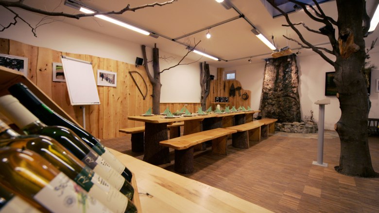 Cozy nature park house with wooden table, a tree in the room and warm wooden interior.