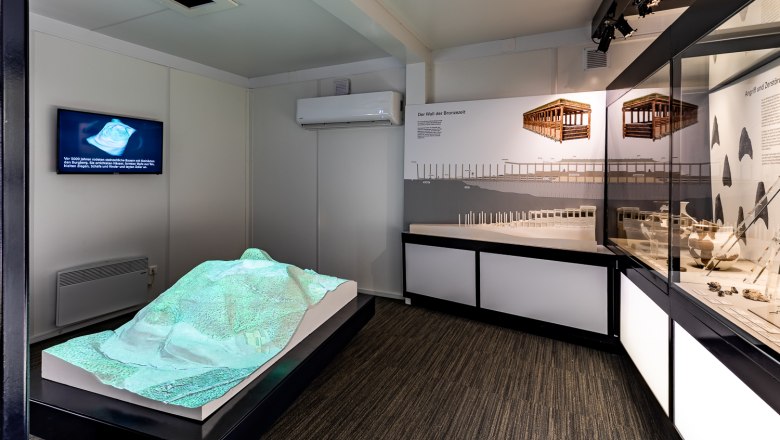 Interior view of an exhibition in the Celtic village of Schwarzenbach with models and information boards.