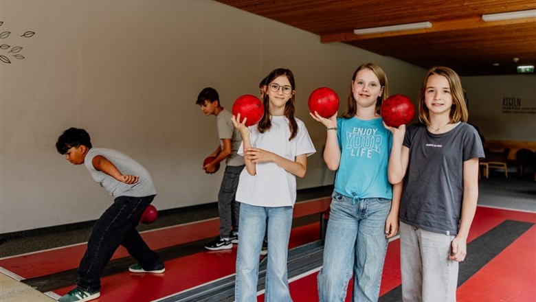 Children playing skittles in a hotel.
