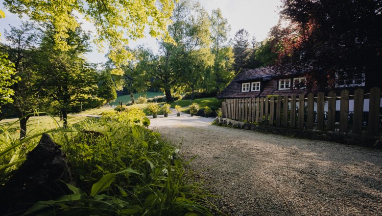 An idyllic country estate with a small house surrounded by trees and a garden path.