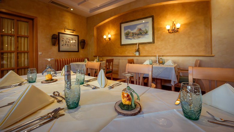 Elegant restaurant with laid tables, white tablecloths and decorative glasses.