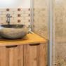 Modern bathroom with natural stone washbasin and wooden cabinet.
