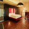 Interior view of a modern bedroom with floating bed, wood paneling and stylish lighting.