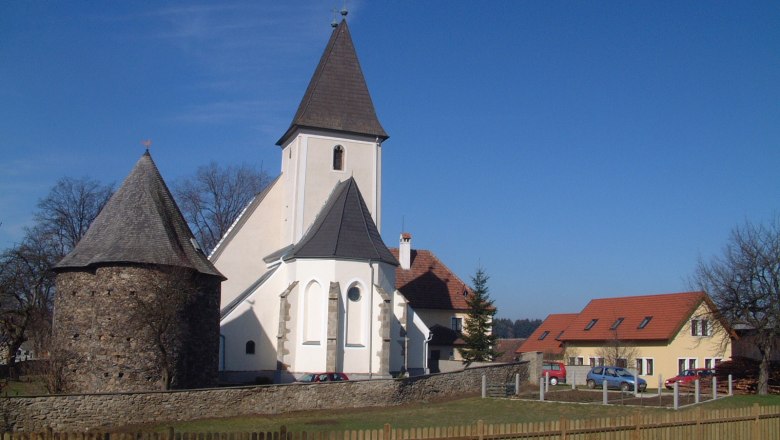 Church and building in Großgöttfritz under a clear sky.