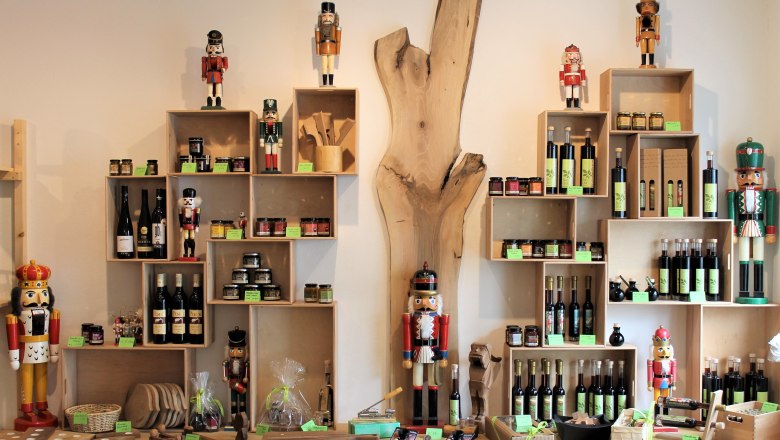 A store shelf with nutcrackers, bottles of wine and gourmet products.