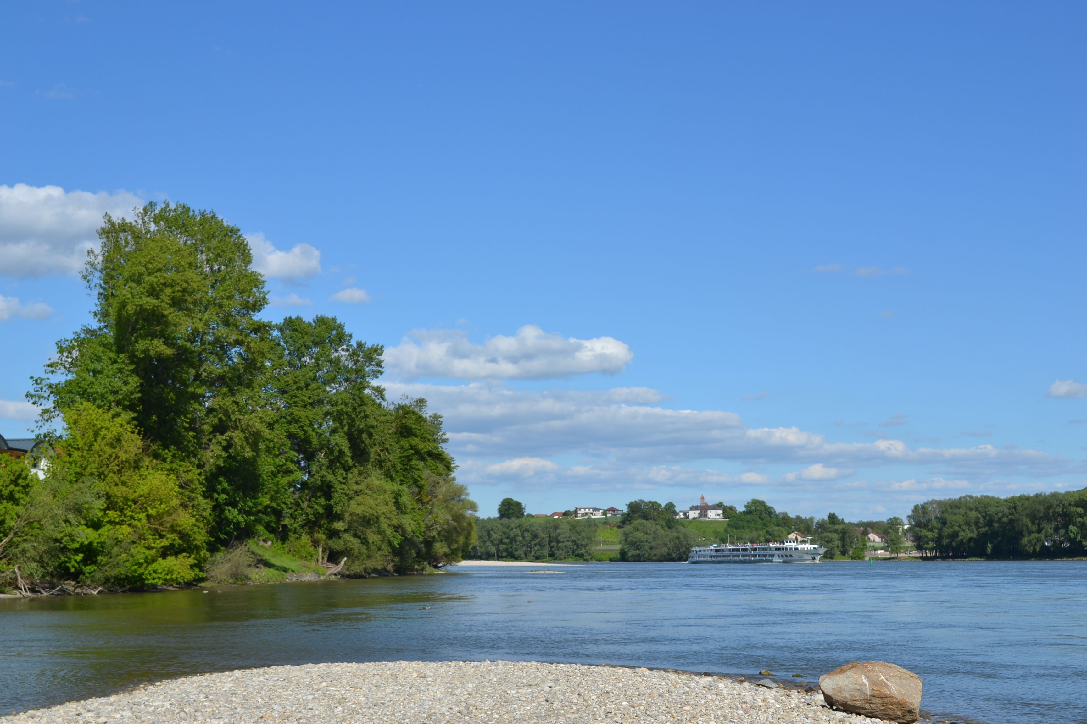 River landscape with trees and a ship on the Danube.
