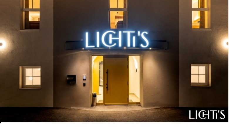 Lichti's Rooms & Apartments, © Lichti´s Appartements-Christian Kremsl Entrance area of a building with illuminated sign 'LICHTI'S'.