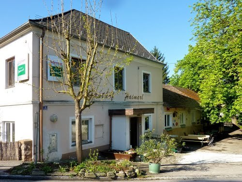 A traditional inn with a white façade and green trees in the background.