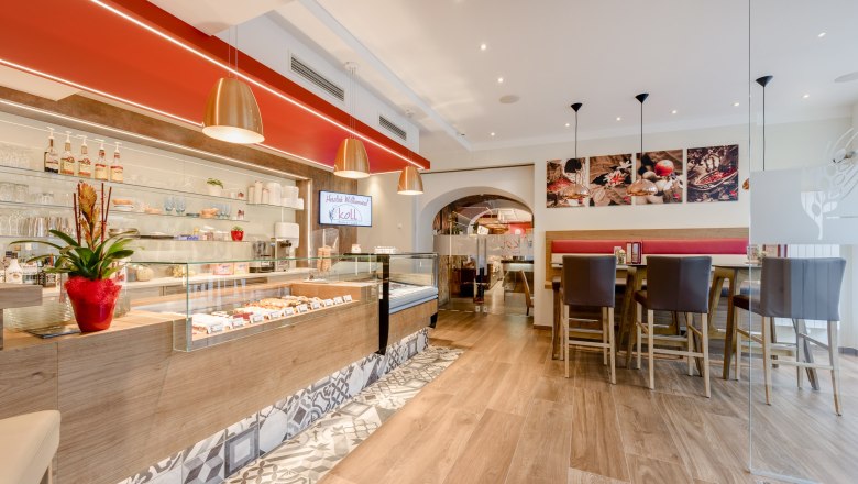 Interior view of a modern bistro with counter, seating area and decorative elements.