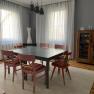 Dining room with table, six chairs, display cabinet and curtains.