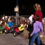 Children play with a toy tractor in a cowshed.