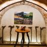 Vaulted wine cellar with table and grapevine decoration.