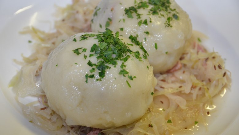 Two grammel dumplings on sauerkraut, garnished with parsley.