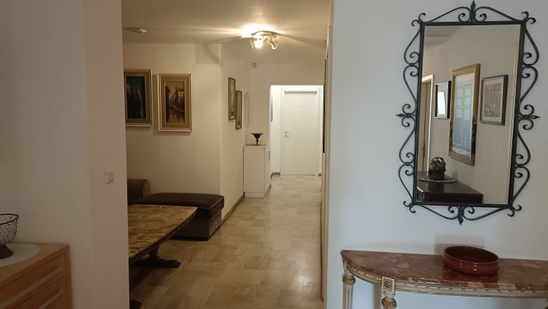 Hallway with mirror, paintings and furniture in an inn.
