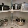 Kitchen cupboard with pots and pans on rotating shelves.