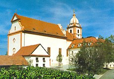 Maria Roggendorf pilgrimage church with red roof and tower against a blue sky.