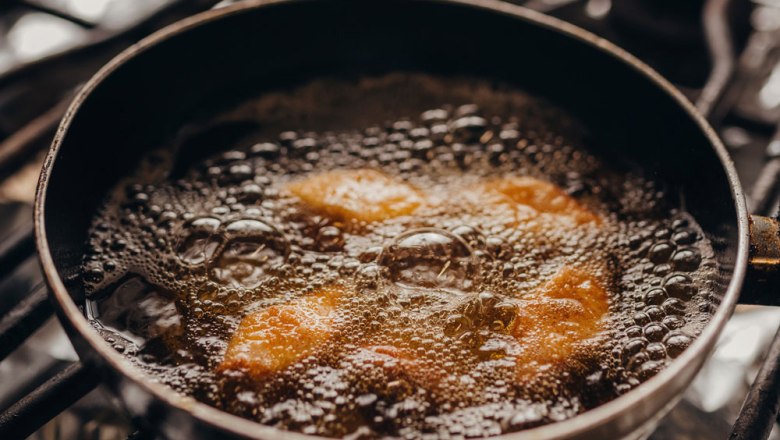 Close-up of a pan with bubbling oil and deep-fried pieces.