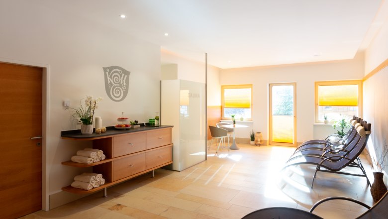 Modern wellness area with loungers, sauna and decoration.