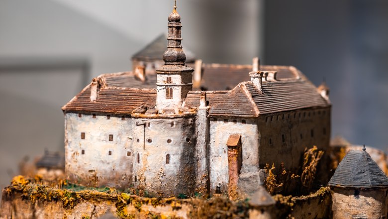 Miniature model of a castle with tower and battlements.