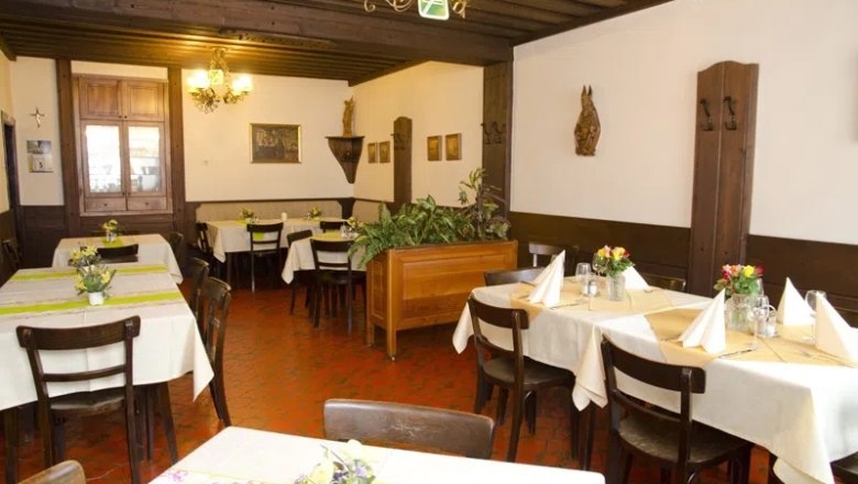 Interior view of a traditional restaurant with wooden furniture and decorated tables.