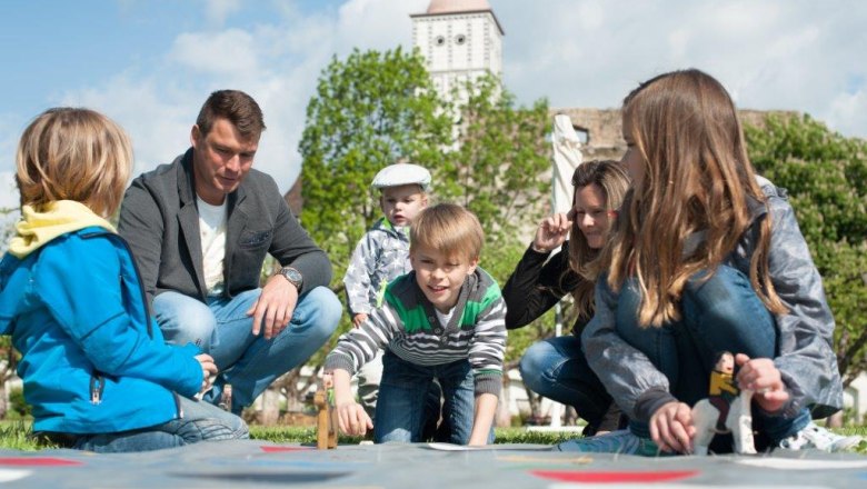 Laughing children and their parents play together at the colorful family festival.