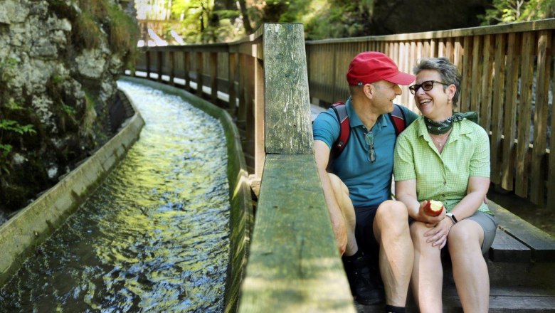 A couple takes a break on the steps of the footbridge, right next to the Trift Canal.